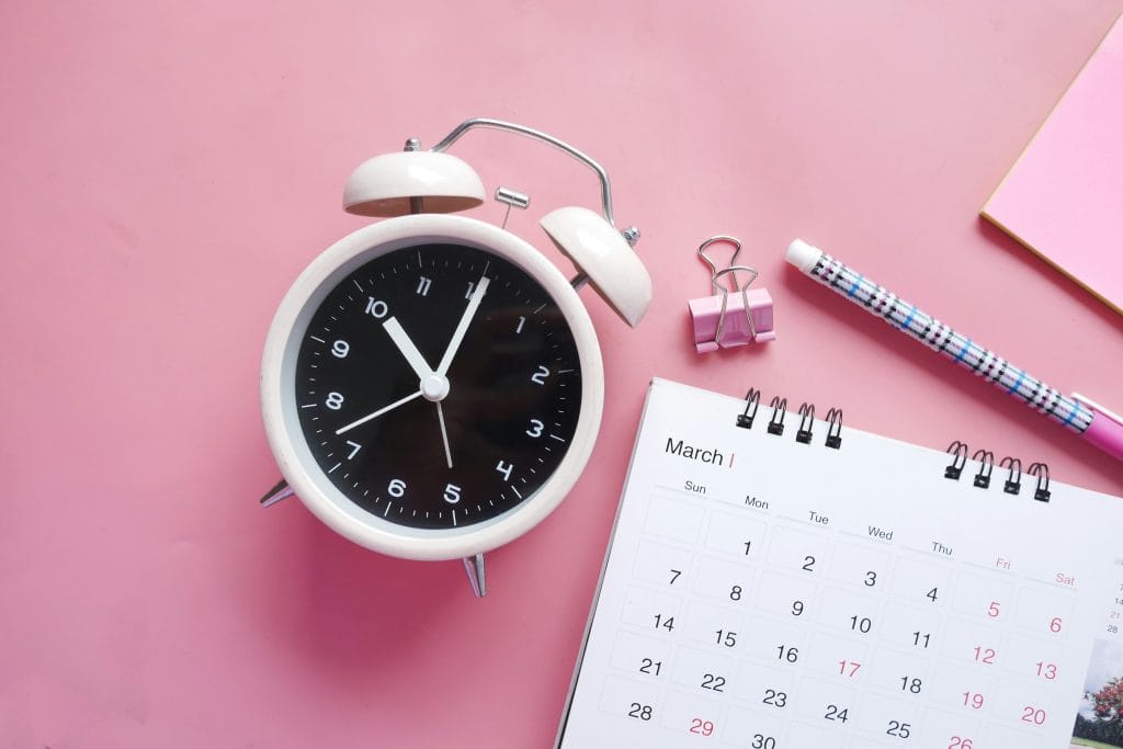 Clock and calendar on pink background